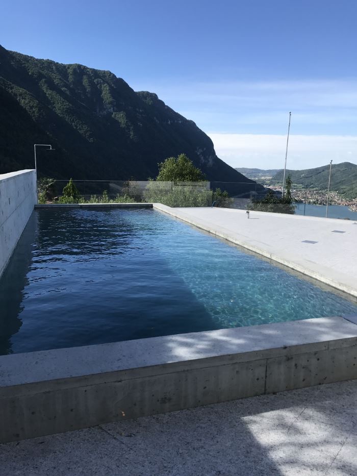 Pool mit Sichtbetonwand vor Bergkulisse