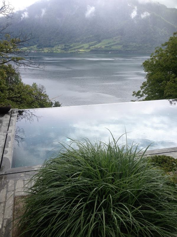 Überlaufpool mit Blick über den See auf die Berge